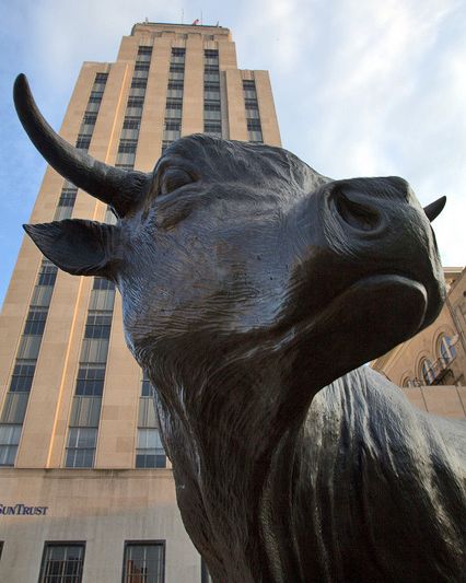 Major the Bull, the bronze bull sculpture in CCB Plaza, downtown Durham, with the art-deco Hill Building rising behind it